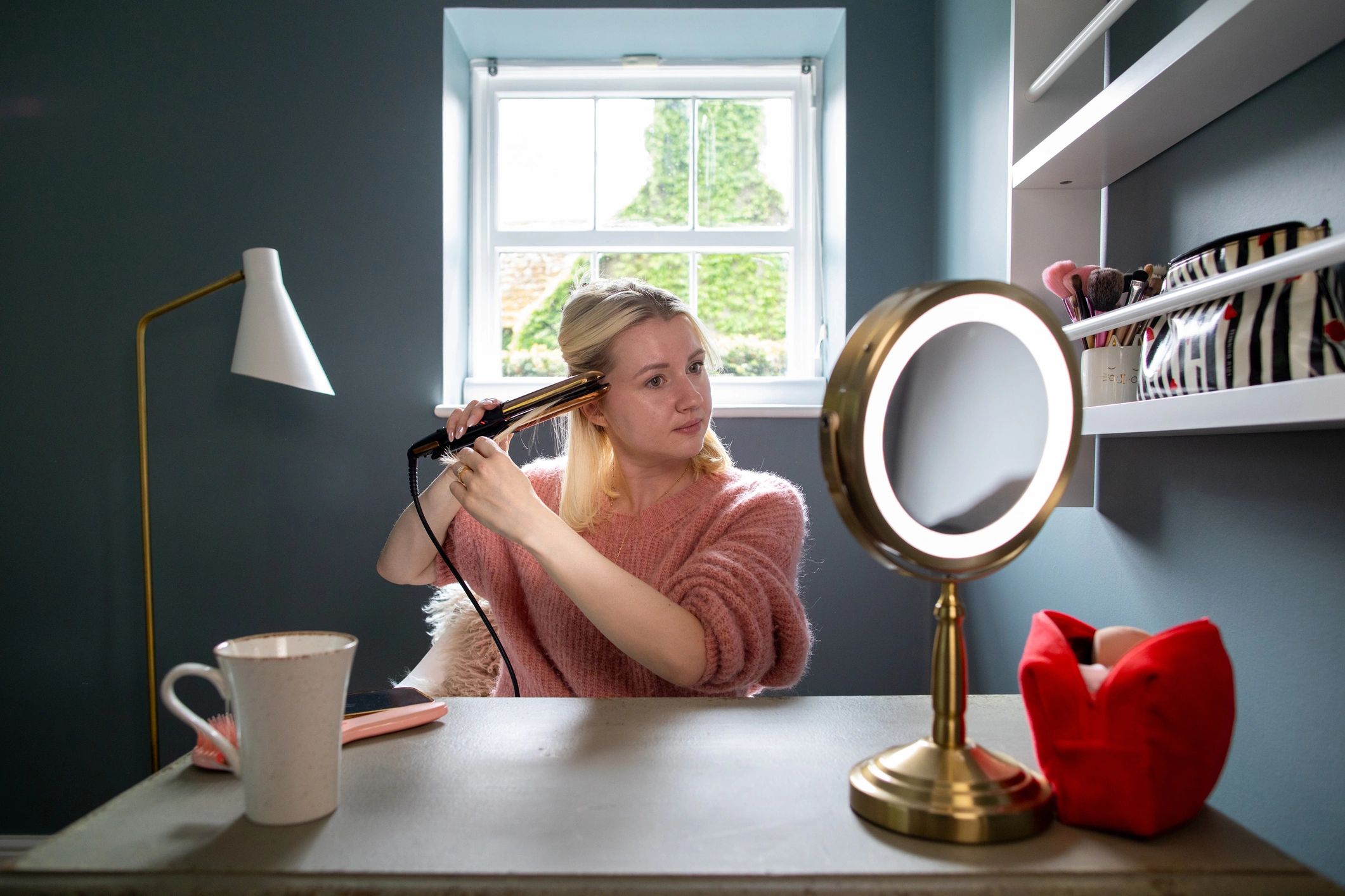 Woman styling her hair in front of a mirror