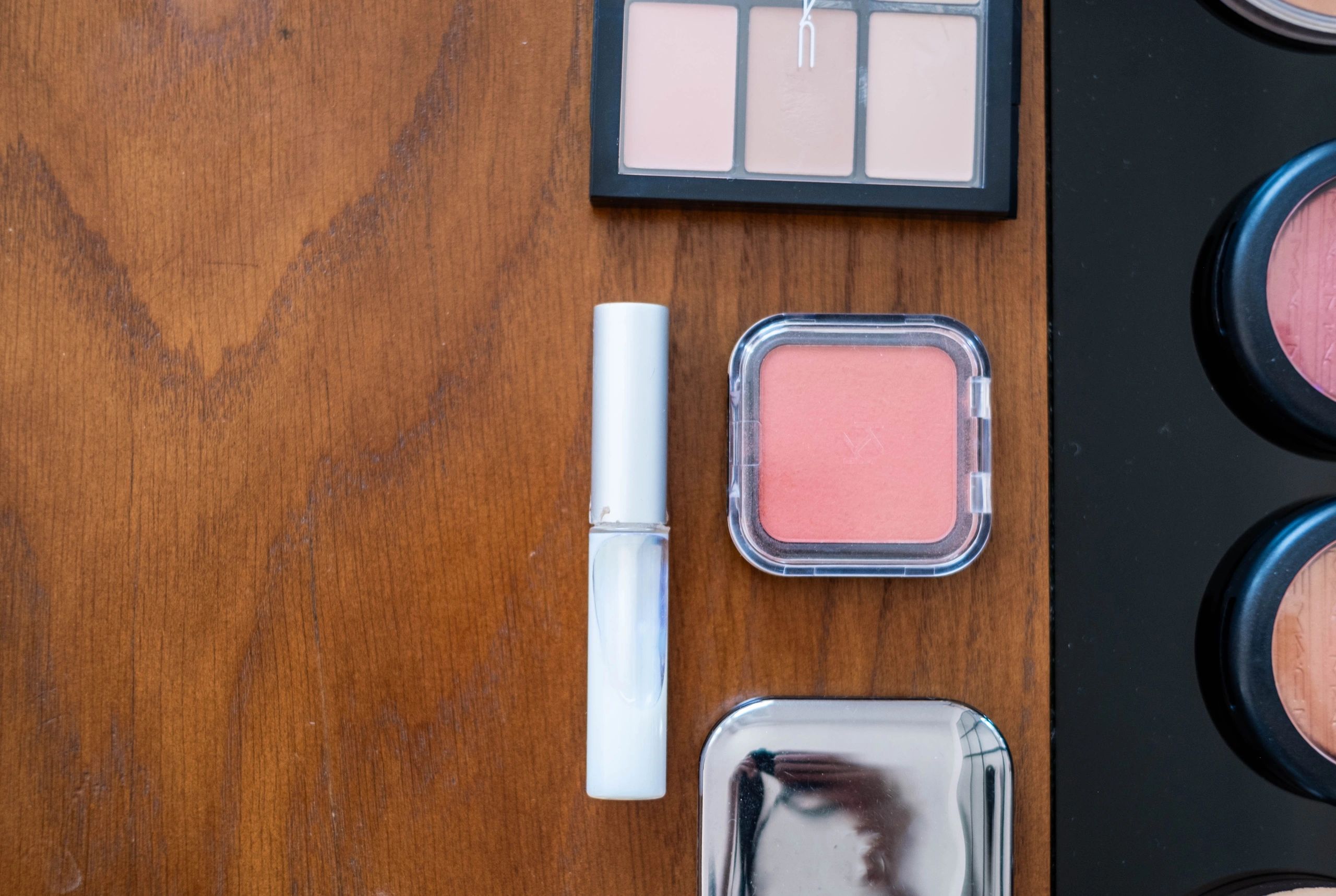 Beauty and makeup products arranged on a wooden surface